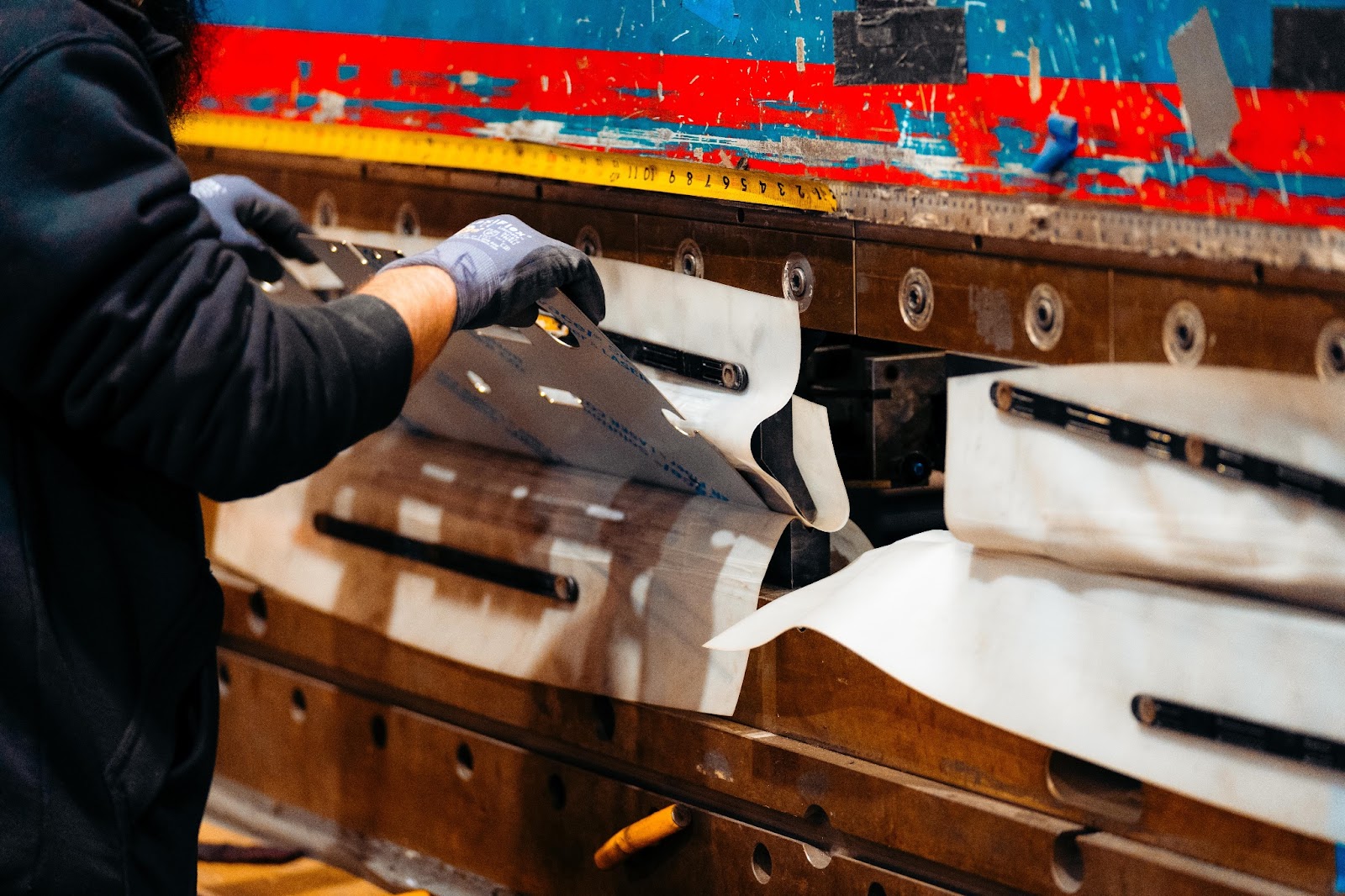 An employee forming a piece of stainless steel on a press brake